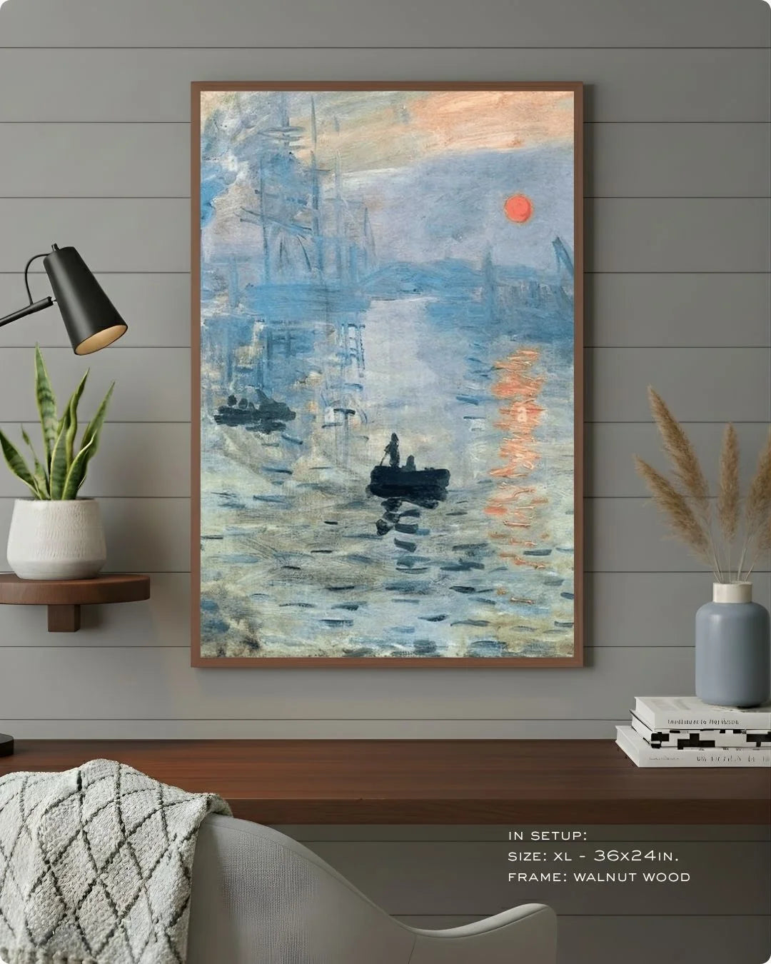 Monet's Impression, Sunrise in a warm Walnut Wood frame by K2C Co., styled against a grey wood-paneled wall with a black desk lamp and indoor plants.