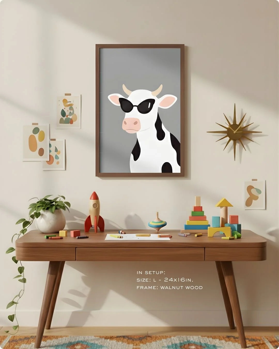 Large (Size L - 24x16in) cow with sunglasses art in a Walnut Wood frame, demonstrating scale above a modern wood desk with a retro starburst clock.