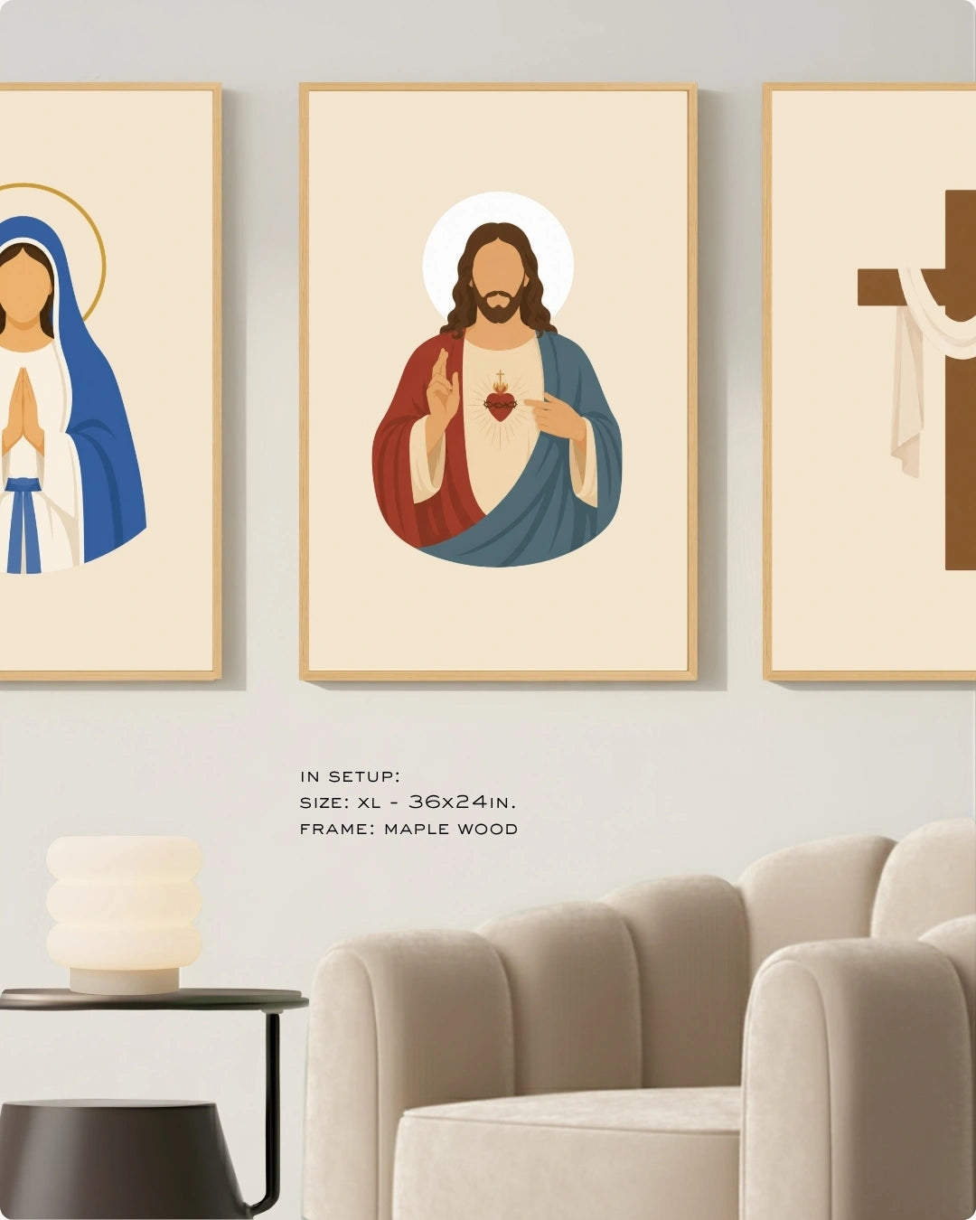 Three framed wall art prints with stylized religious illustrations hang on a light gray wall above a beige sofa. The center print shows Jesus with a halo and red heart, flanked by partial prints of the Virgin Mary and a brown cross.