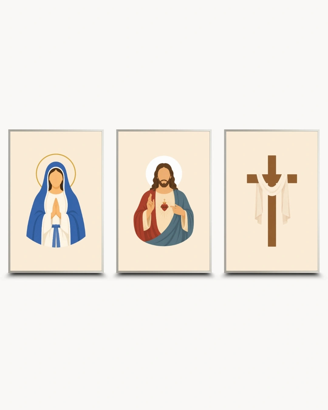 Three framed minimalist religious wall art prints on a light gray background. The left print shows the Virgin Mary in blue and white with a gold halo, the center print shows Jesus with a red and blue robe and a white halo, and the right print shows a brown Christian cross with white draped fabric.