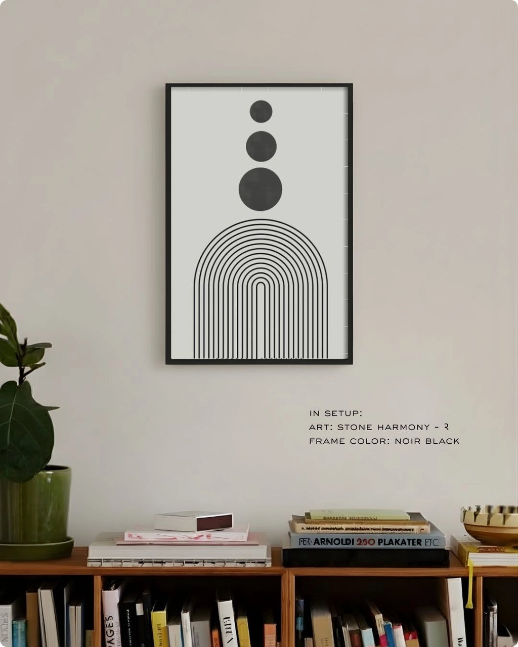 Stone Harmony 2 abstract wall art by K2C Co. featuring three charcoal grey circles and black arches in a Noir Black frame, displayed in a minimalist living room mockup above a wooden bookshelf.