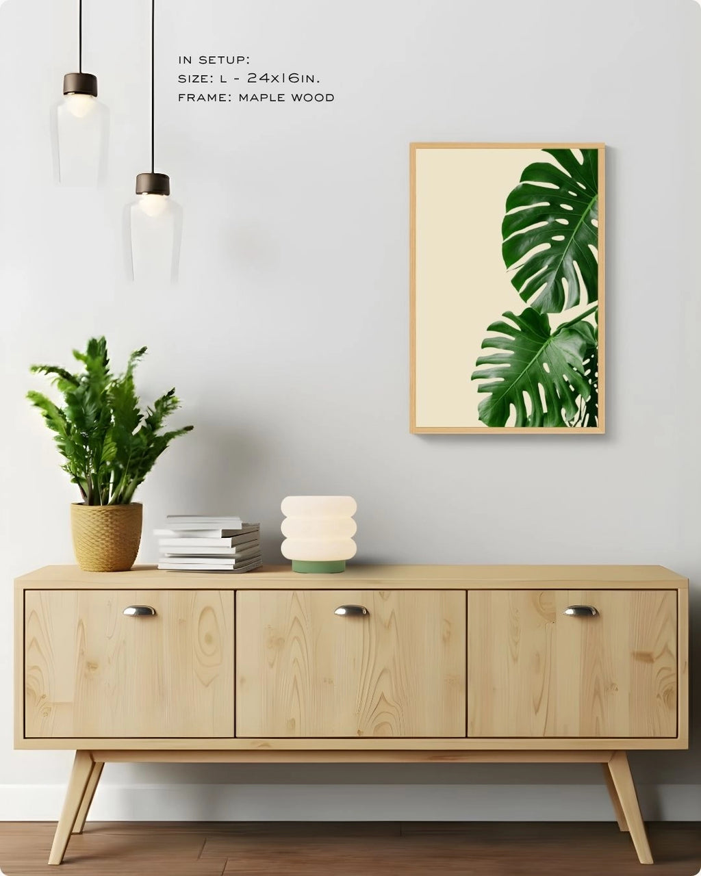 Minimalist banana leaf wall art by K2C Co. in a Maple Wood frame, styled in a bright living room setup with hanging pendant lights and a designer mushroom table lamp.