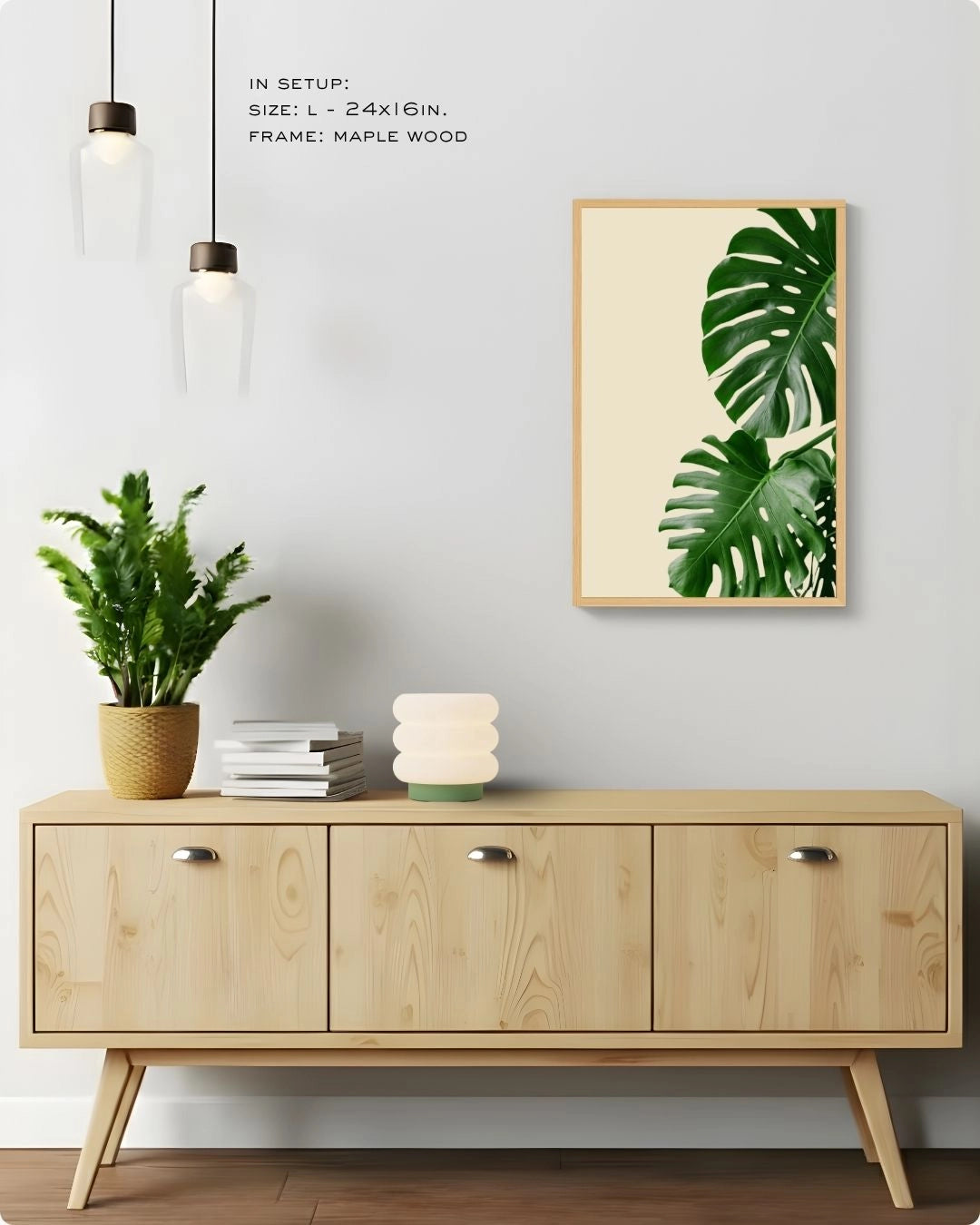 Minimalist banana leaf wall art by K2C Co. in a Maple Wood frame, styled in a bright living room setup with hanging pendant lights and a designer mushroom table lamp.