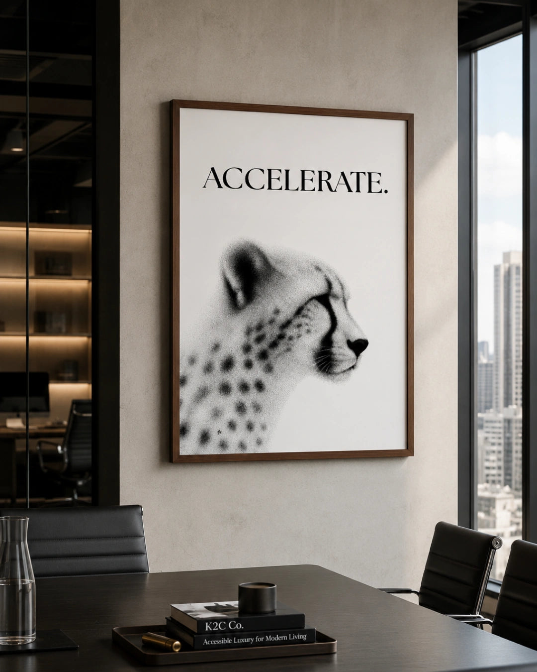 A framed black and white art print featuring a cheetah profile with the word 'ACCELERATE.' above it, displayed on a light gray wall in a modern office setting.