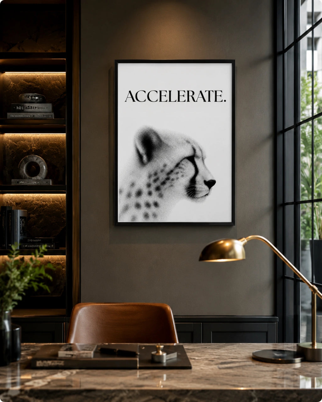 A framed black and white art print featuring a cheetah and the word 'ACCELERATE.' hanging on a dark gray wall in a modern office setting with a desk, chair, and lamp.