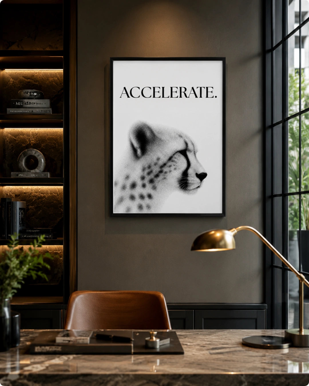 A framed black and white art print featuring a cheetah and the word 'ACCELERATE.' hanging on a dark gray wall in a modern office setting with a desk, chair, and lamp.