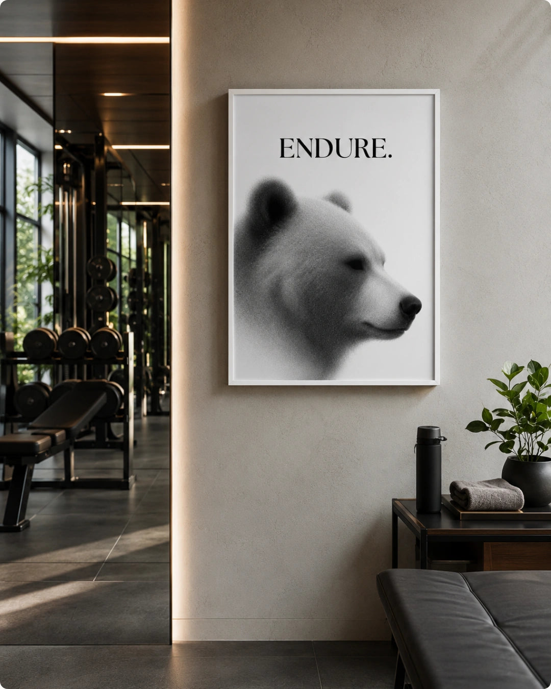 A framed black and white art print featuring a polar bear profile with the word 'ENDURE.' above it, displayed on a beige wall in a modern interior setting.