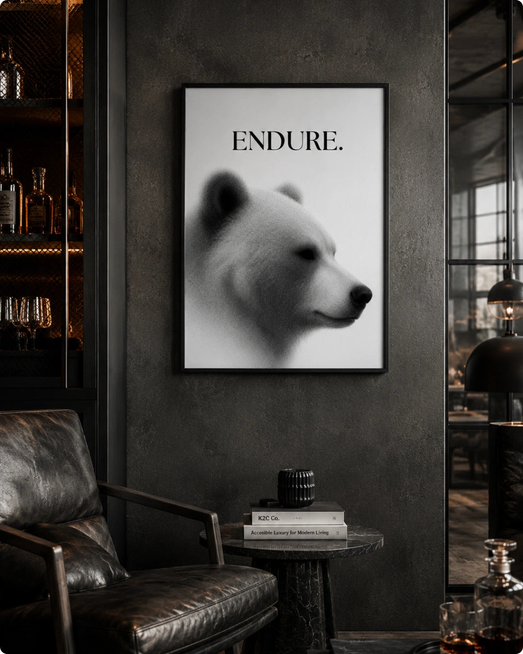 A framed black and white art print featuring a polar bear profile with the word 'ENDURE.' above it, displayed on a dark textured wall in a moody, modern living room setting.