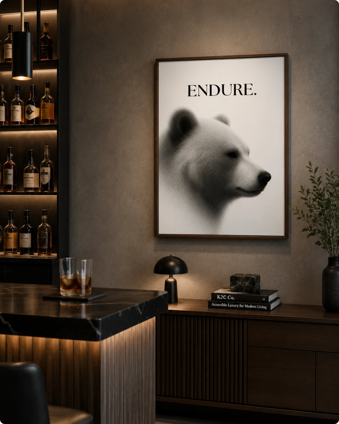 A framed wall art print featuring a black-and-white polar bear portrait with the word 'ENDURE.' at the top, displayed in a modern bar or lounge setting above a counter.
