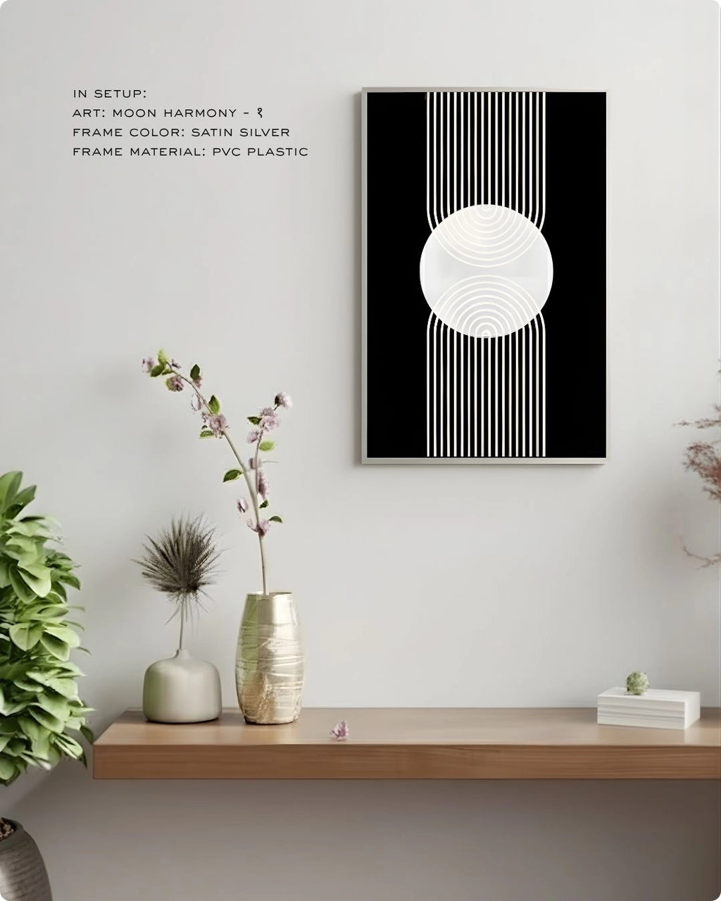 Moon Harmony 1 abstract wall art by K2C Co. featuring a white geometric circle and lines on a solid black background in a Satin Silver frame, displayed in a minimalist living room mockup with floral decor.